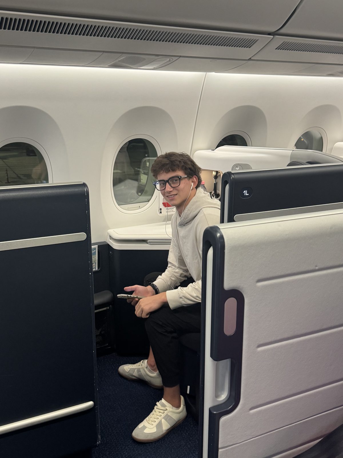 A teenager settling into a business-class suite for the flight to Paris.