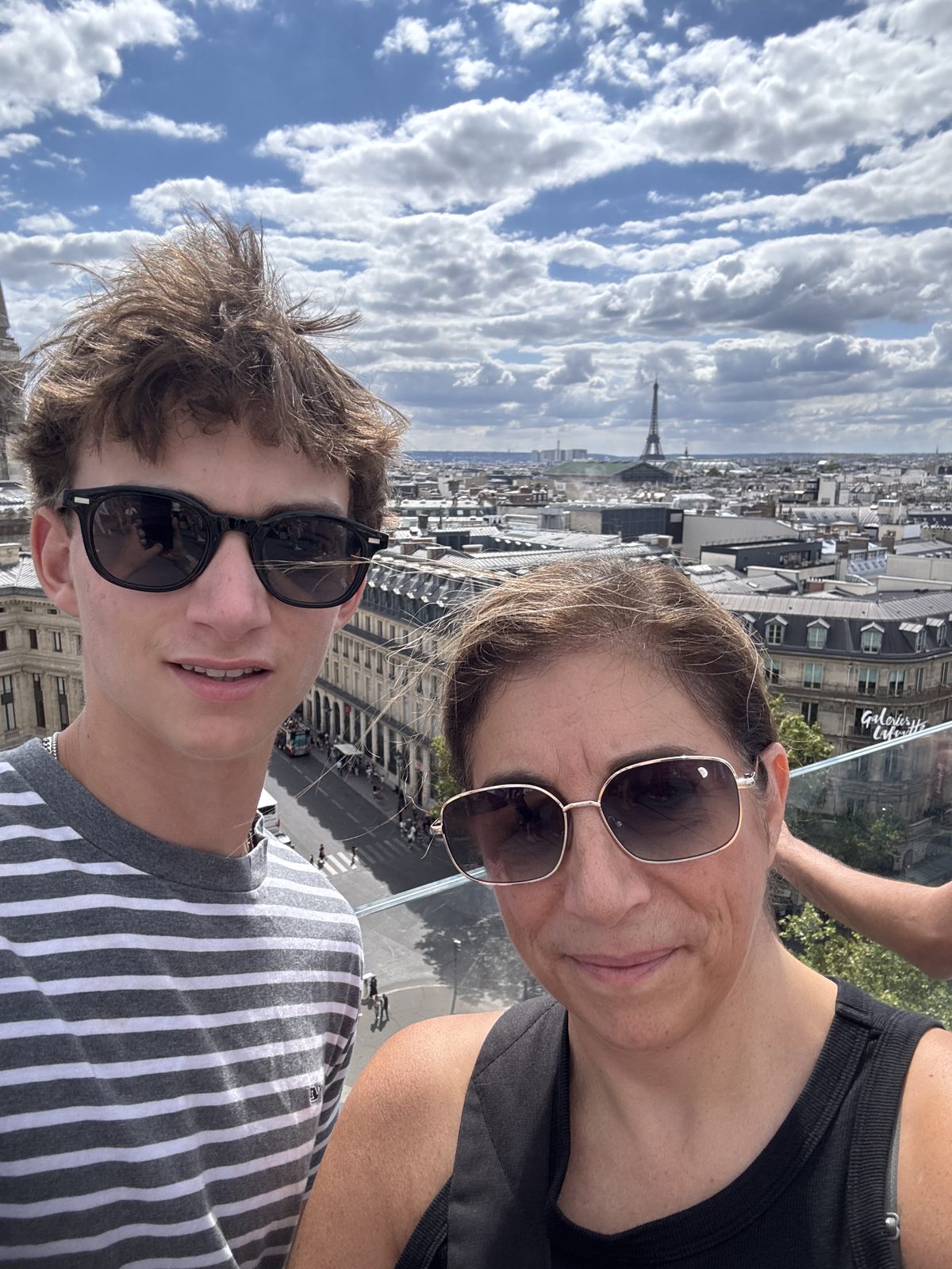 A rooftop selfie over the Paris skyline with the Eiffel Tower in the distance.
